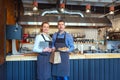 Smiling young man and woman using tablet at small eatery restaurant